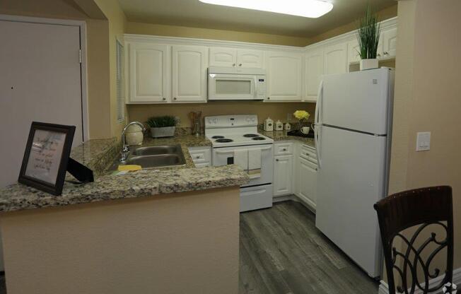 Kitchen With White Cabinetry And Appliances at Citrus Gardens Apartments, Fontana, CA 92335