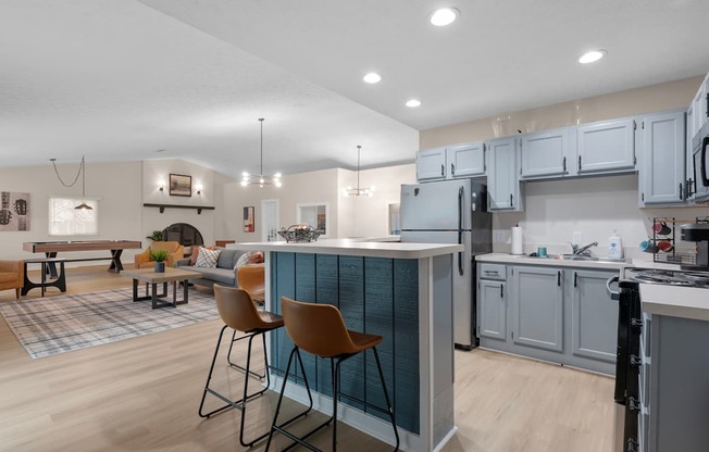 A kitchen with a bar area and chairs.