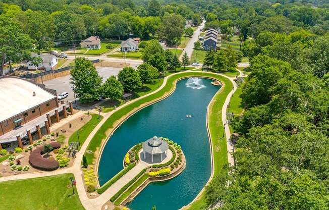 A serene landscape with a pond and a gazebo.