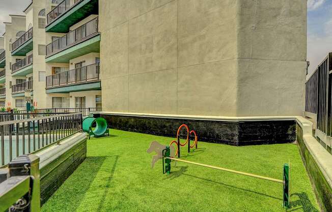 A playground with a green lawn and a white fence.