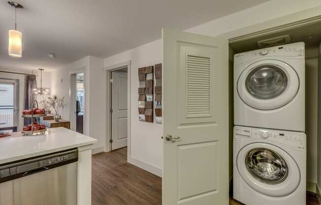 a washer and dryer in a kitchen with a door to the laundry room