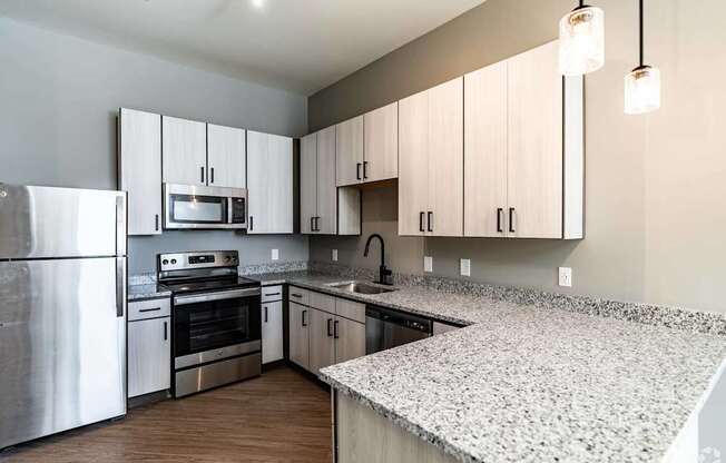 A kitchen with a stove, oven, and microwave.