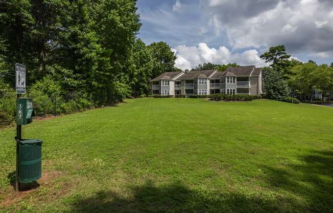 a green lawn in front of a house with a green mailbox