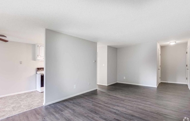 a living room with a hard wood floor and white walls