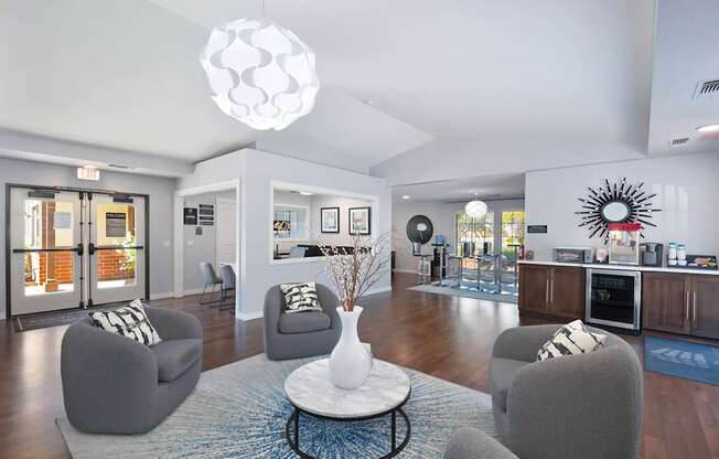 A modern living room with a grey sofa, a white coffee table, and a large chandelier.