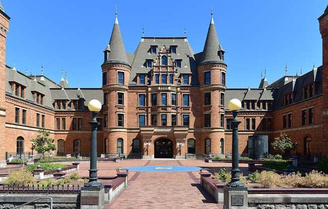 A large castle-like building with a courtyard in front.