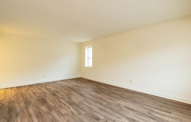 an empty room with white walls and a window  at Charlesgate Apartments, Maryland