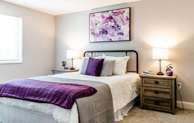 a bedroom with a bed and two night stands with lamps