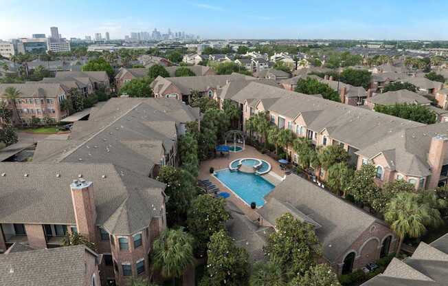 A bird's eye view of a residential area with houses and a swimming pool.