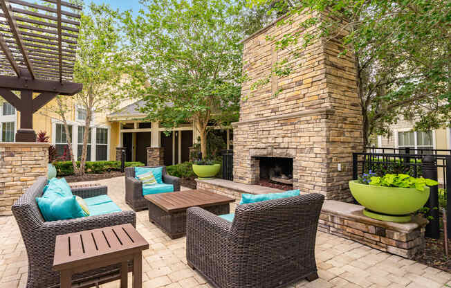 an outdoor patio with tables and chairs and a fireplace