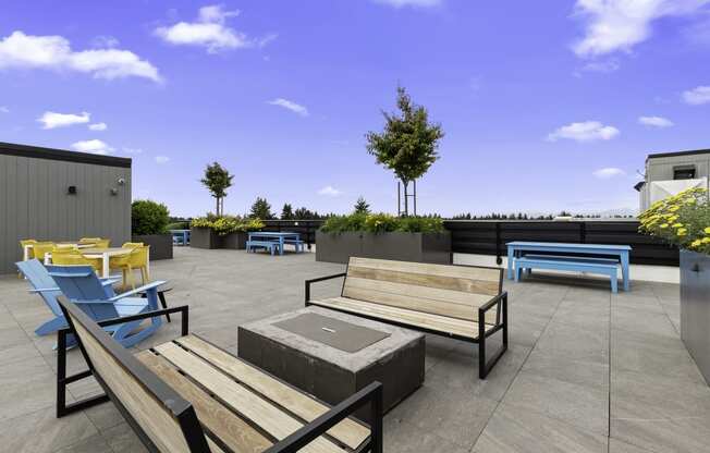 Rooftop Lounge Area with Benches, Blue Adirondack Chairs, and Cozy Firepit at Arabella Apartment Homes, Shoreline, Washington 98155