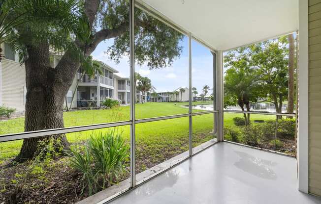 the view from the living room of a house with large windows overlooking a grassy