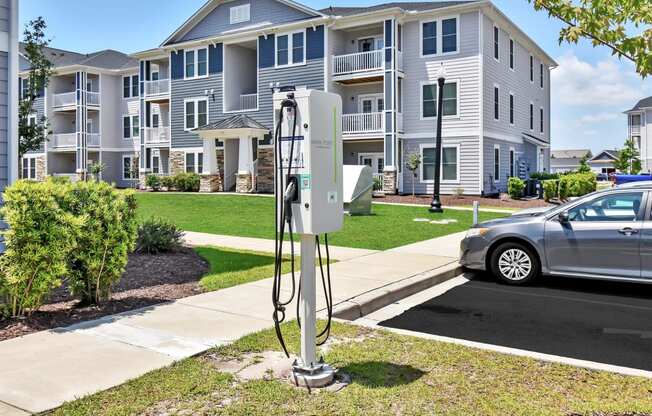 an electric car parked in front of an apartment building