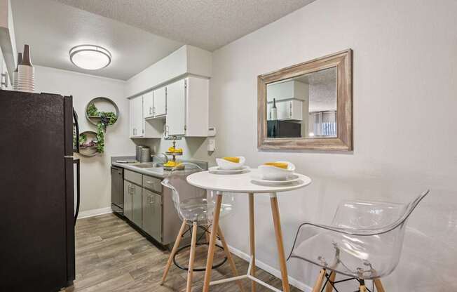 A kitchen with a table and chairs.