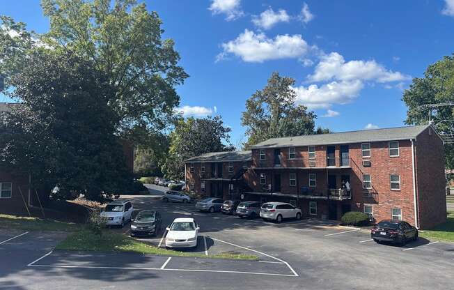 A parking lot with cars and a building in the background.