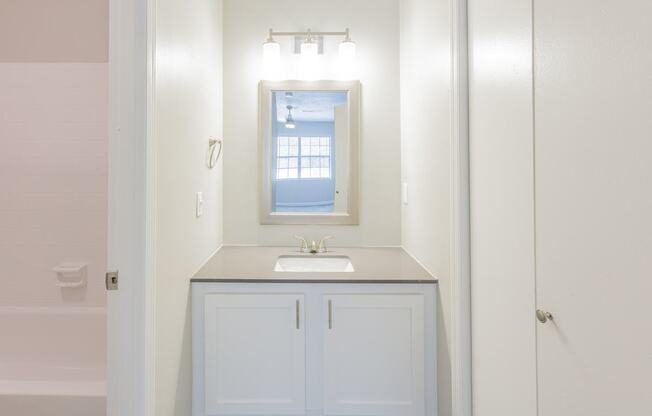A bathroom with a sink and a mirror.