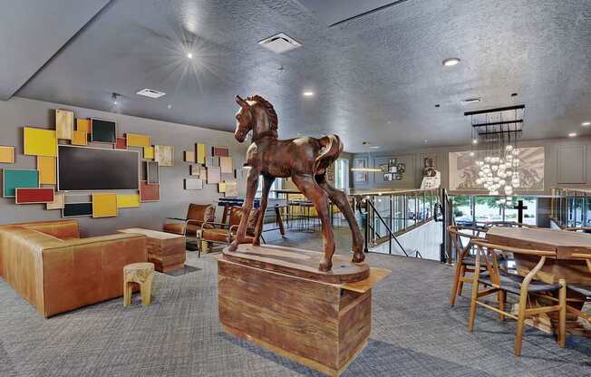 A room with a wooden horse statue on a pedestal.