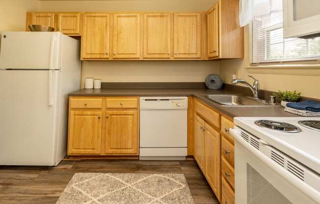 a kitchen with white appliances and wooden cabinets
