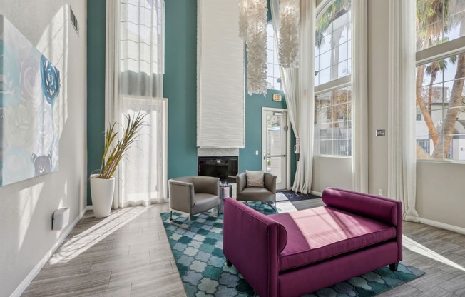 a living room with a purple couch and chairs and a fireplace