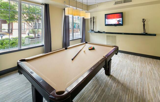 a games room with a pool table and a tv