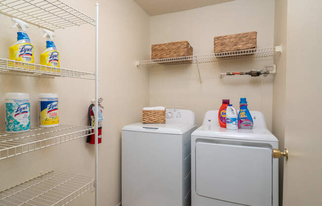 a laundry room with two washes and a dryer in it and a closet