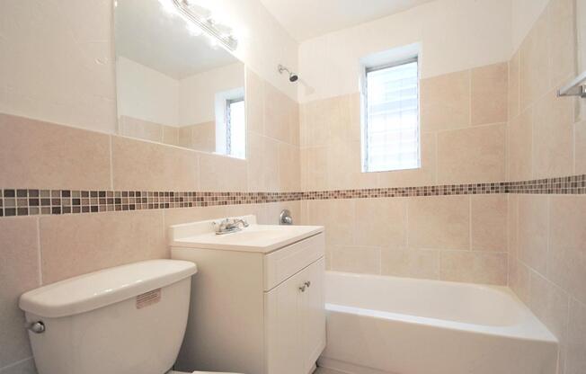A white bathroom with a tub, toilet, and sink.