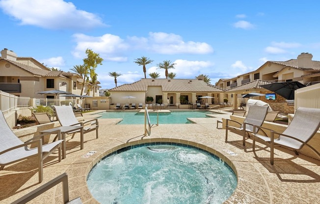 A  spa surrounded by lounge chairs in a sunny outdoor setting.