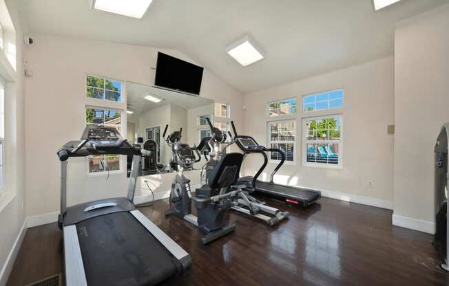 the gym has plenty of exercise equipment and a flat screen tv