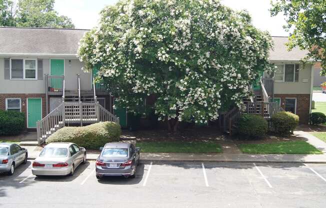 an apartment building with cars parked in a parking lot