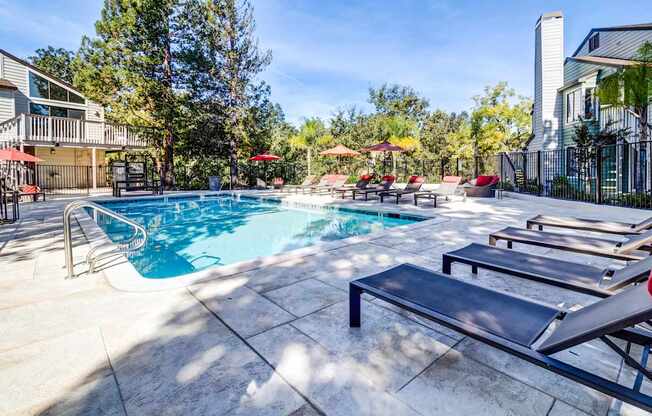 A pool with a slide and sun loungers.
