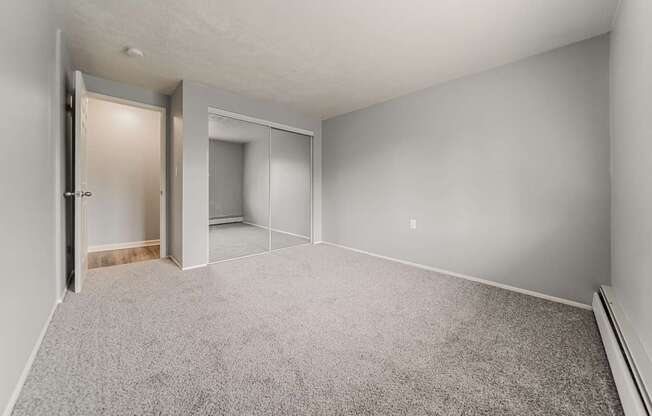 A room with a carpeted floor and a doorway leading to another room.