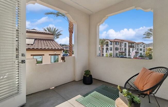 a balcony with a chair and a view of a palm tree at Arrive Temecula