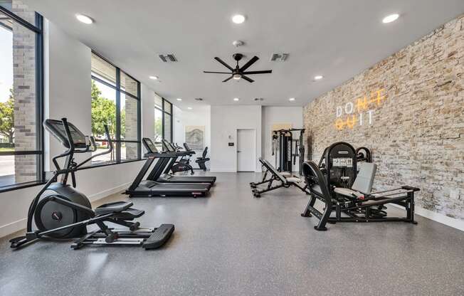 A gym with treadmills, elliptical machines, and a weight bench.