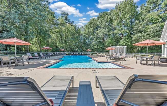 a swimming pool with lounge chairs and umbrellas at the resort