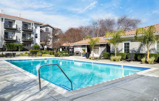 A swimming pool surrounded by a concrete patio and apartment buildings at Cornerstone at Gale Ranch Apartments, San Ramon, CA