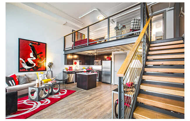 A living room with a red rug and a painting on the wall.