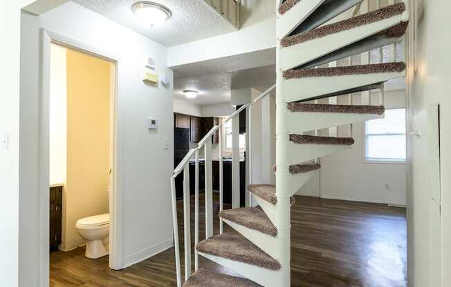 A white staircase with a carpeted runner leads to a second floor at Spring Creek Townhomes Apartments, Springfield, Illinois