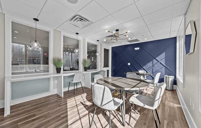 a dining room with a table and chairs and a blue accent wall