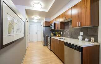 a kitchen with wooden cabinets and stainless steel appliances and a white counter top