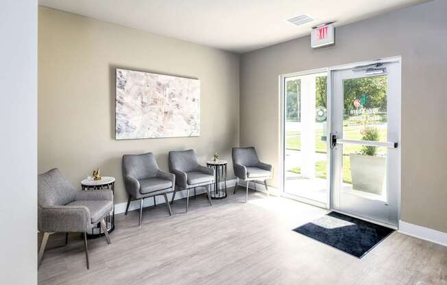 A waiting room with grey chairs and a painting on the wall.