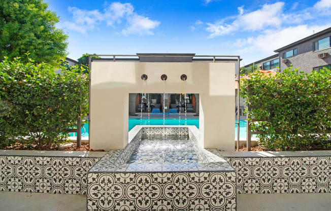 a pool with a fountain in the middle of a house