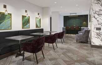 a room with tables and chairs and a bar in the background at The Encore at Ingram Manor, Pikesville