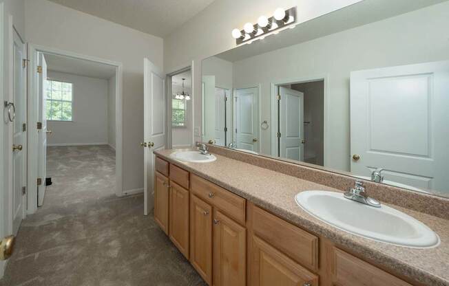 A bathroom with a sink, mirror, and cabinets.