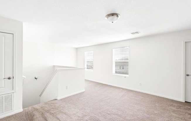the loft bedroom with white walls and carpet
