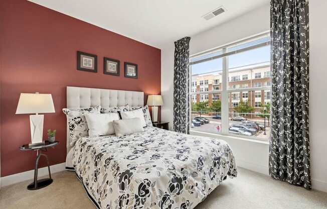 A bedroom with a large bed and a window overlooking a parking lot.