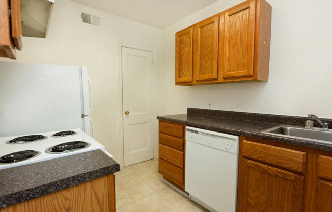 a kitchen with white appliances and wooden cabinets