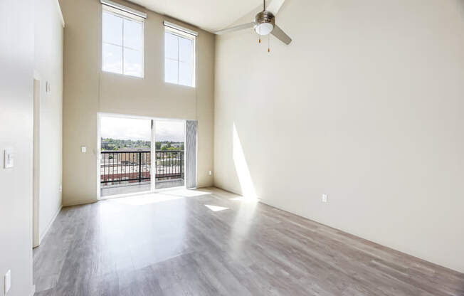 A room with a balcony and a ceiling fan.