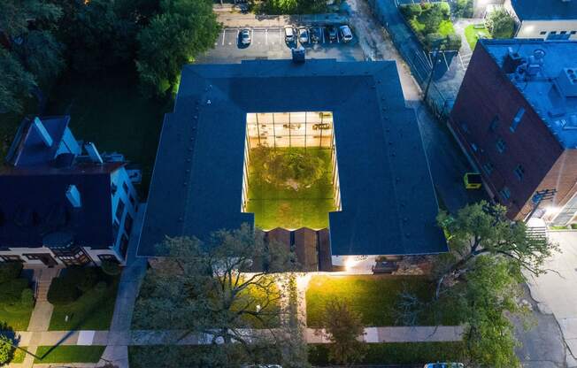 an aerial view of a building at night with a green roof