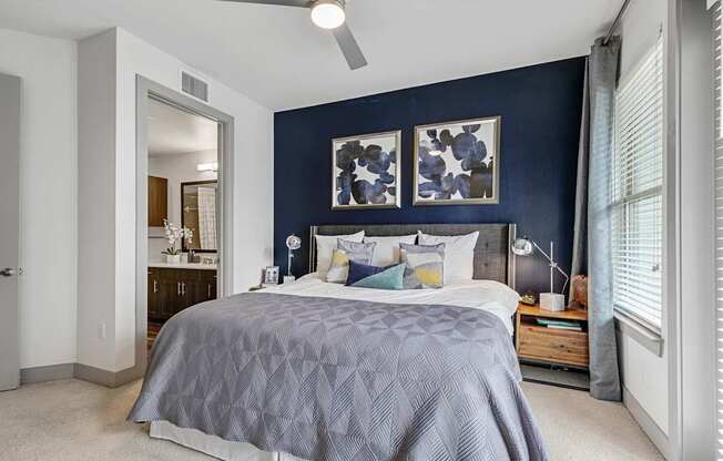 A bedroom with a bed, nightstand, and a ceiling fan.