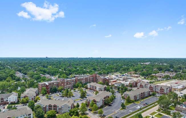 A view of a residential area with apartment buildings and a parking lot.